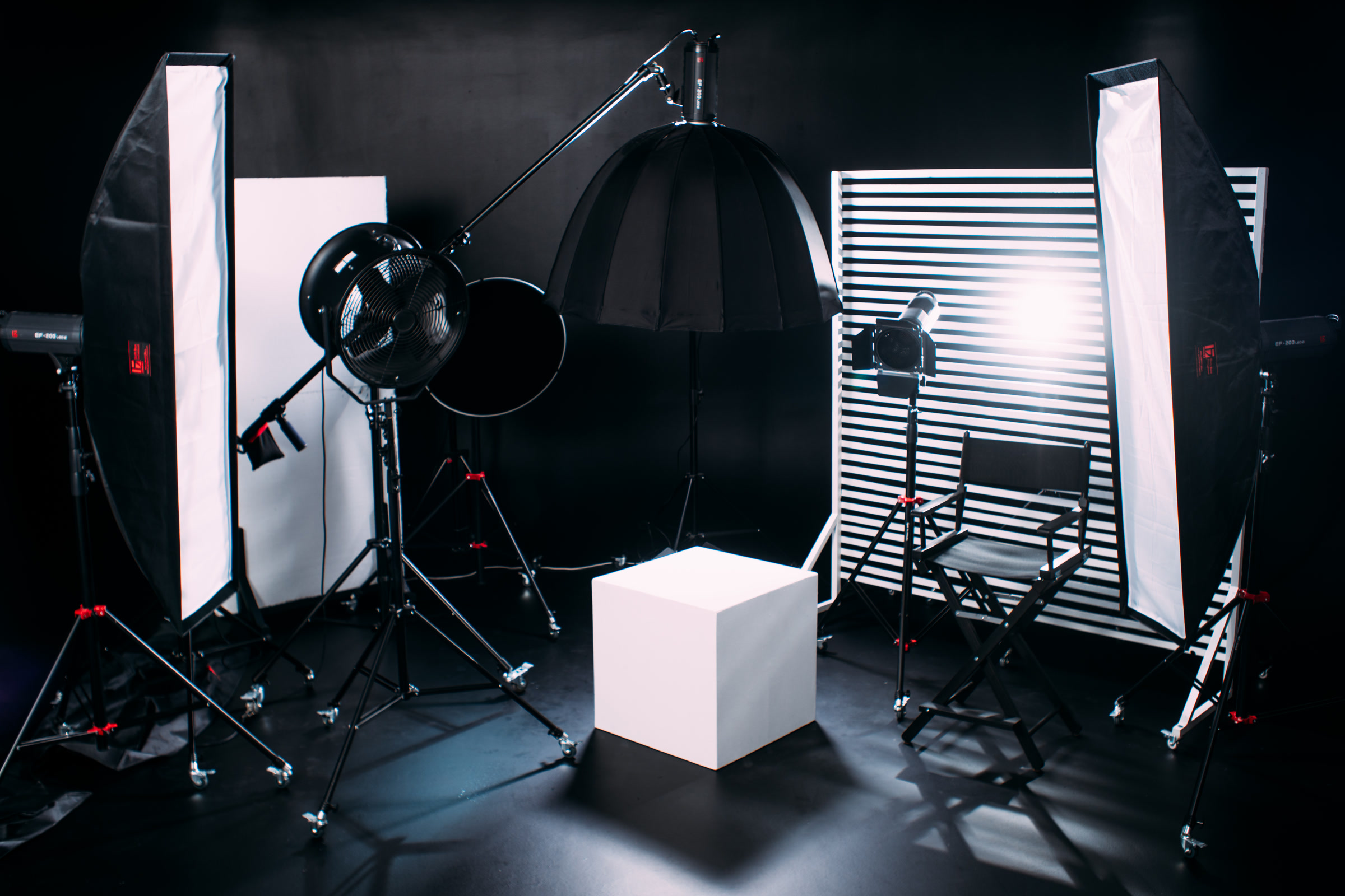 Photo studio with softboxes, lights, and a director chair